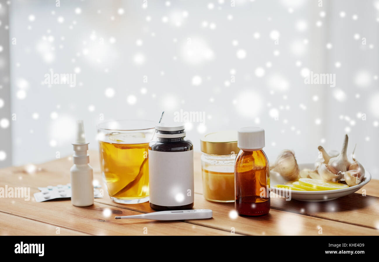 La drogue, thermomètre, le miel et une tasse de thé sur bois Banque D'Images