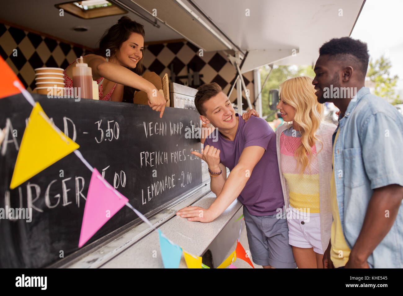 Vendeur menu montrant aux clients au camion alimentaire Banque D'Images