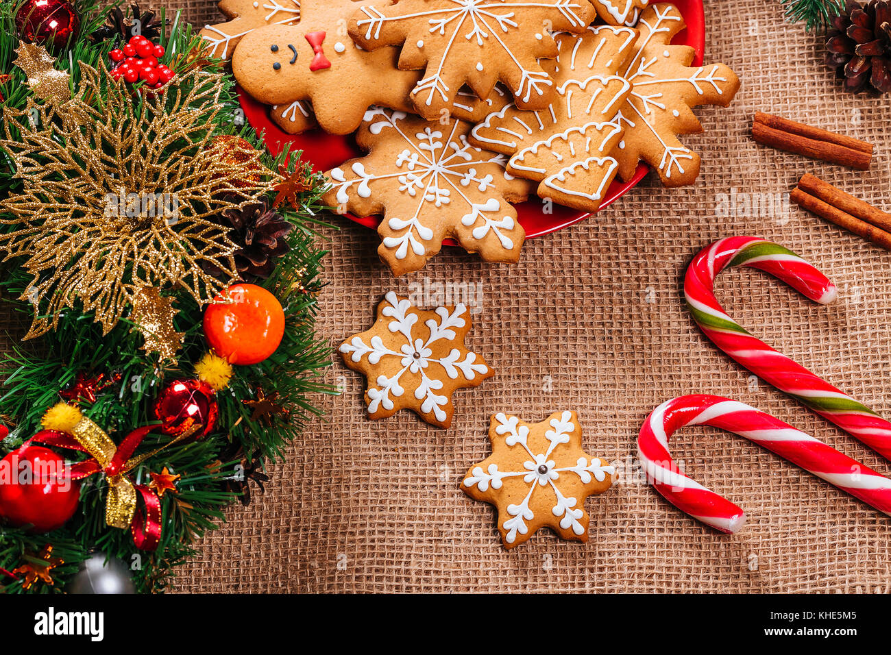 Gingerbread cookies de Noël dans la maison de la plaque rouge avec des branches de sapin de noël et nouvel an décor sur table avec nappe de toile. merry christma Banque D'Images