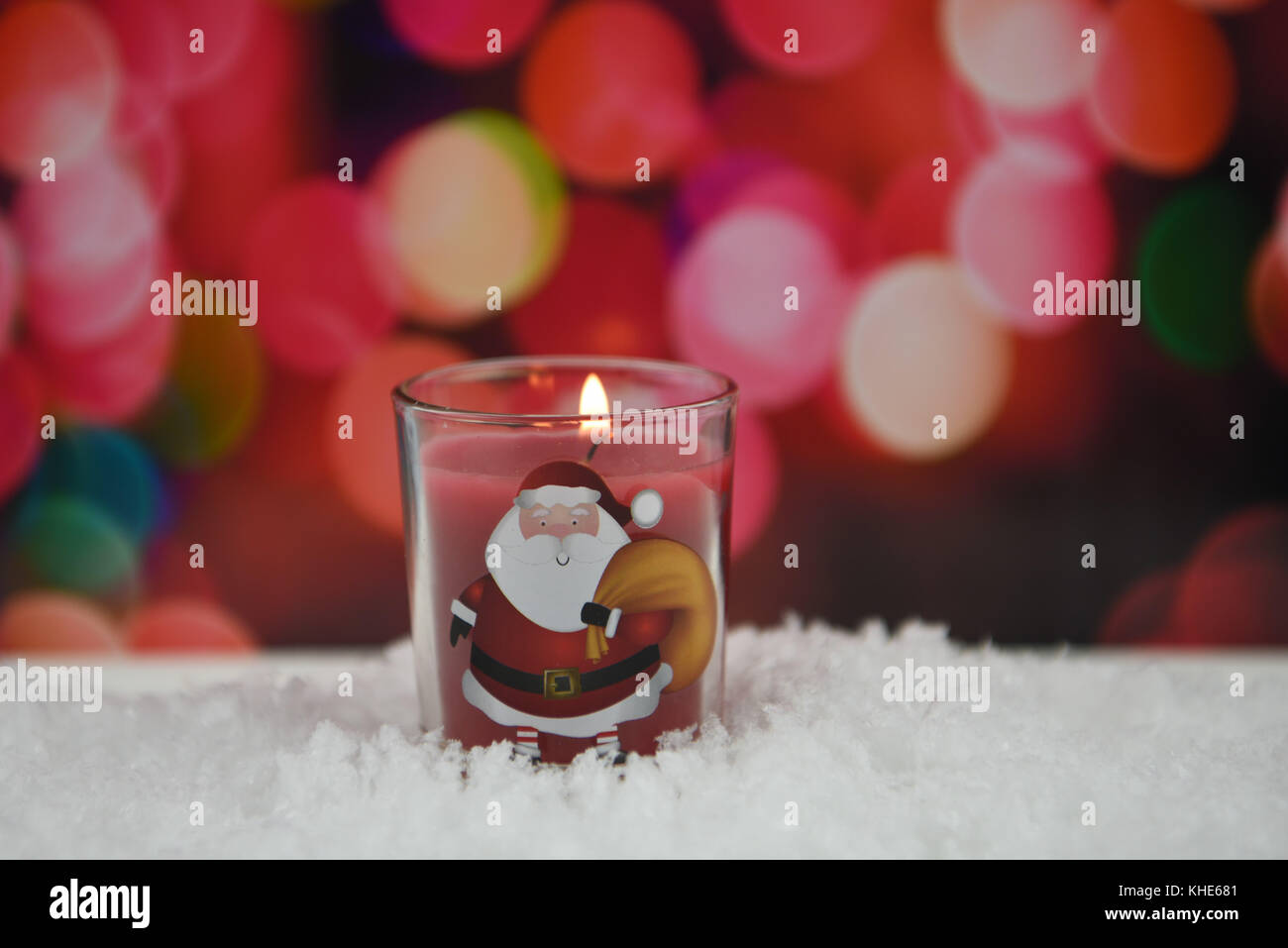 Photographie de Noël image de bougies rouges en verre avec flamme allumée debout dans la neige avec confortable chaude couleur jaune rose rouge motif de fond Banque D'Images