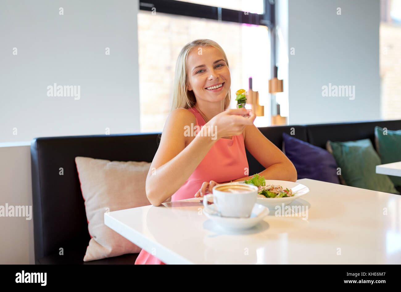 Happy young woman eating déjeuner au restaurant Banque D'Images