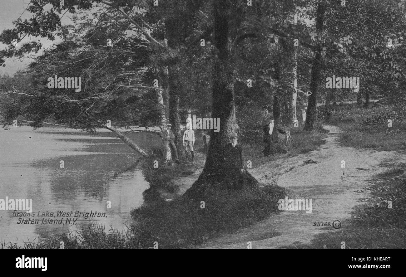 Carte postale colorée à la main avec des personnes debout contre des arbres sur le rivage, marquée Brook's Lake, West Brighton, Staten Island, New York, 1900. De la bibliothèque publique de New York. Banque D'Images