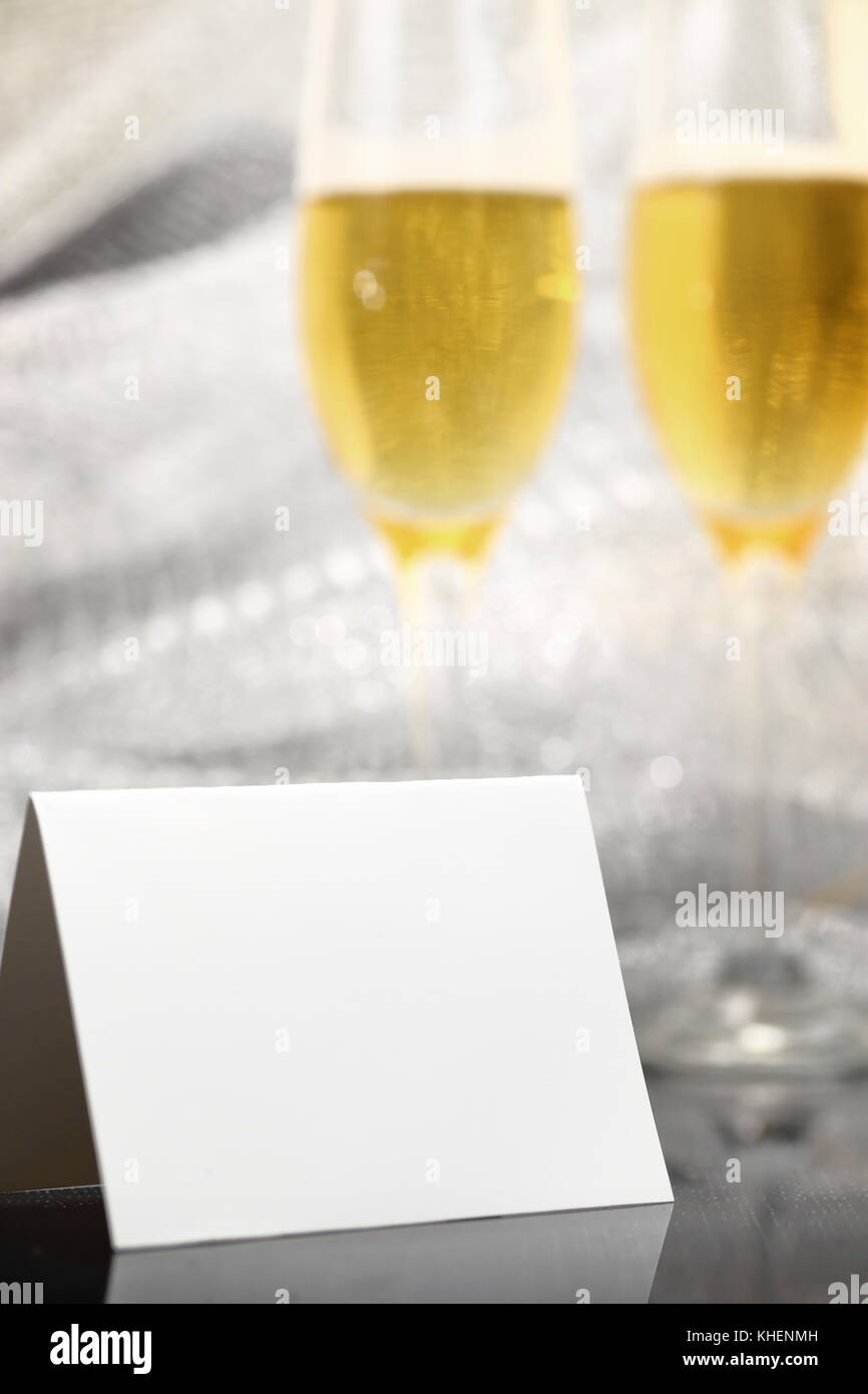 Carte avec deux verres de champagne et l'arrière-plan flou d'argent Banque D'Images