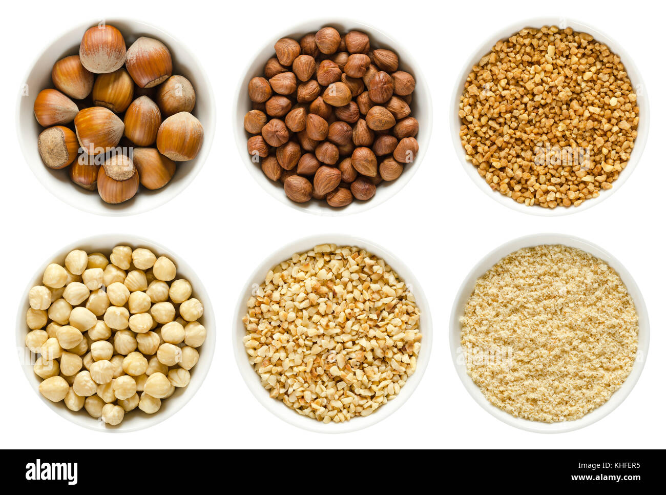 Les noisettes en blanc bols. fruits entiers, écossés, blanchies et coupées grossièrement. rez de noisettes et les noisettes cassante. Corylus avellana. macro photo. Banque D'Images