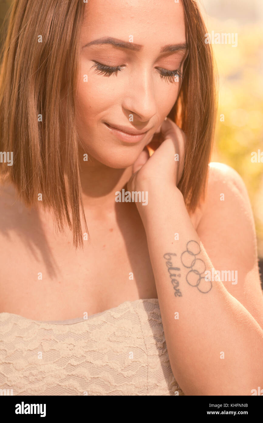 Une jeune femme, à la baisse, tatouage olympique, chef face portrait Banque D'Images