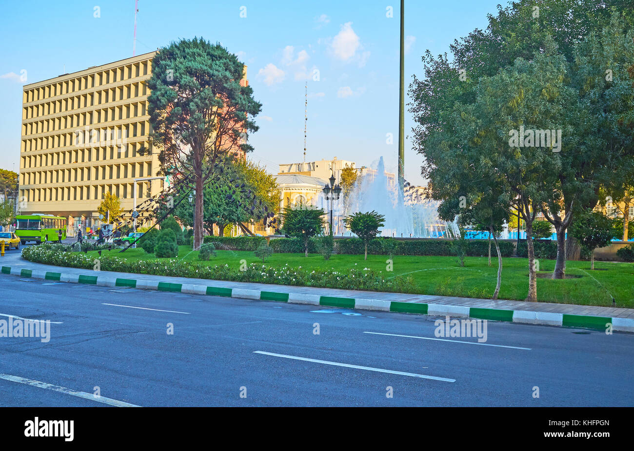 Le matin, promenade le long de l'imam Khomeini square avec parc pittoresque, fontaines et le bâtiment moderne sur l'arrière-plan, Téhéran, Iran. Banque D'Images