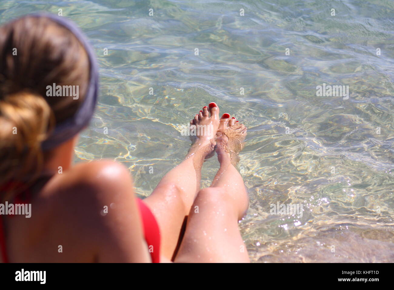 Une jolie jeune femme qui montre ses pieds comme elle apprécie les eaux  claires et chaudes de la plage Photo Stock - Alamy