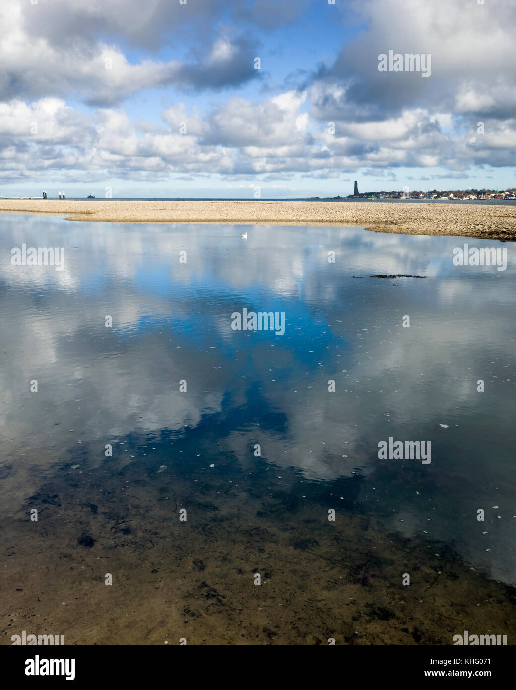 Kieler Förde, Kiel. Allemagne Deutschland. Une vue sur la plage et la mer du fjord de Kiel, Kieler Förde, Allemagne, Deutschland. Le mémorial naval de Laboe à n'est qu'à l'horizon de l'autre côté du fjord. C'est une journée ensoleillée avec des nuages blancs, qui ont été saisis dans les réflexions de la piscine de la mer toujours au premier plan. Banque D'Images