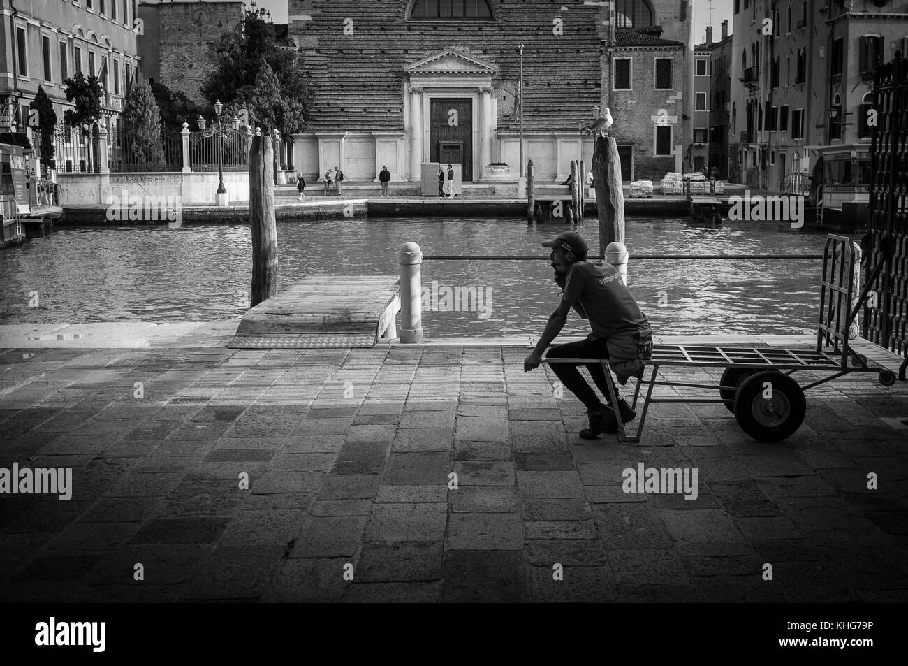 Fin de la journée de travail à Venise pour cette livraison homme ou est-il juste d'attendre la prochaine charge à déposer pour lui d'offrir. La photographie de rue Banque D'Images