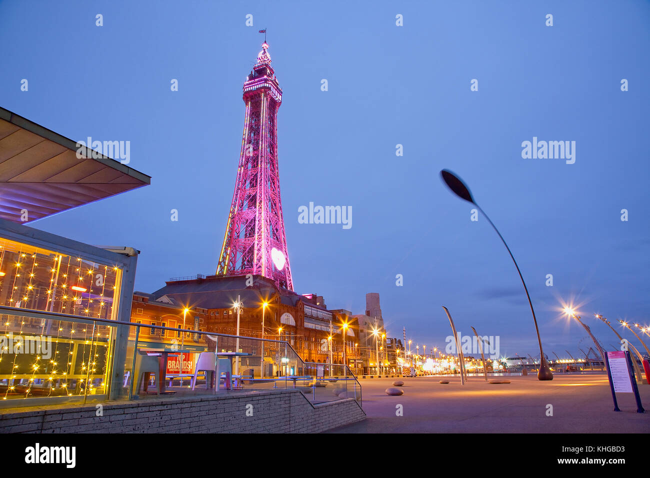 L'Angleterre, dans le Lancashire, Blackpool, promenade du front de mer avec tour illuminée au crépuscule. Banque D'Images