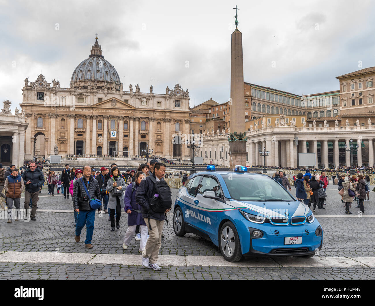 Voiture de police italienne entourée de touristes asiatiques sur place Pierre, Cité du Vatican. La menace terroriste reste élevée. Banque D'Images