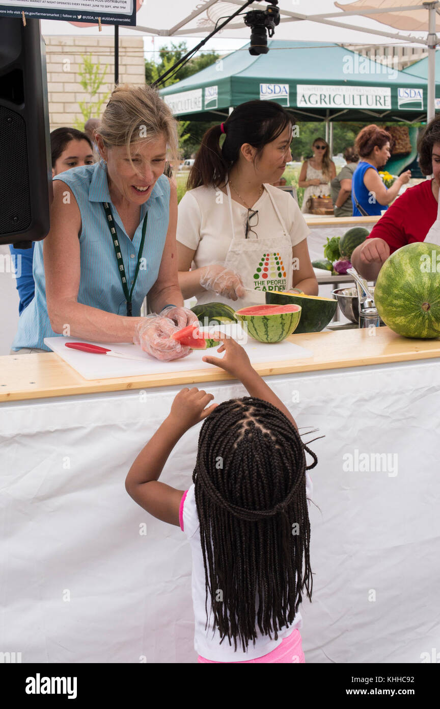 Département de l'Agriculture des États-Unis (USDA) Agricultural Marketing Services (AMS) la nutritionniste Laura Walter donne un morceau de pastèque à Liah Montgomery (3) pendant la préparation de l'USDA Farmers Market vegU recette démonstration d'une pastèque, Cucumber, Et la salade de basilic le vendredi 15 juillet 2016, à Washington, D.C., photo de l'USDA par lance Cheung. -------------------------- Rendements 4 à 6 portions temps de préparation : 15 minutes | temps de cuisson : 0 minutes | temps total : 15 minutes 6 tasses de pastèque 1 tasse de concombre 2 cuillères à soupe d'oignon rouge 1 cuillère à soupe de vinaigre de vin rouge 2 c. à thé d'huile d'olive 2 cuillères à soupe de feuilles de basilic sel et poivre, au goût 1 Banque D'Images