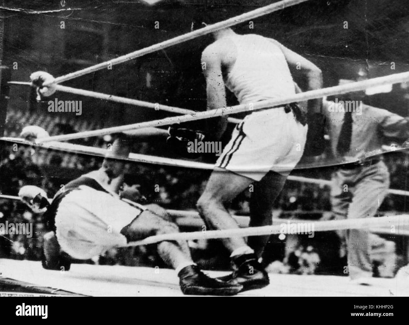 Adrian Holmes, un boxeur, frappe un adversaire au tapis lors des Jeux olympiques de Londres de 1948. La photographie capture un moment charnière du match, mettant en valeur l'intensité et l'athlétisme de la compétition. Les Jeux olympiques de Londres ont marqué un événement important dans l'histoire olympique, mettant en évidence le talent et la détermination des athlètes. Banque D'Images