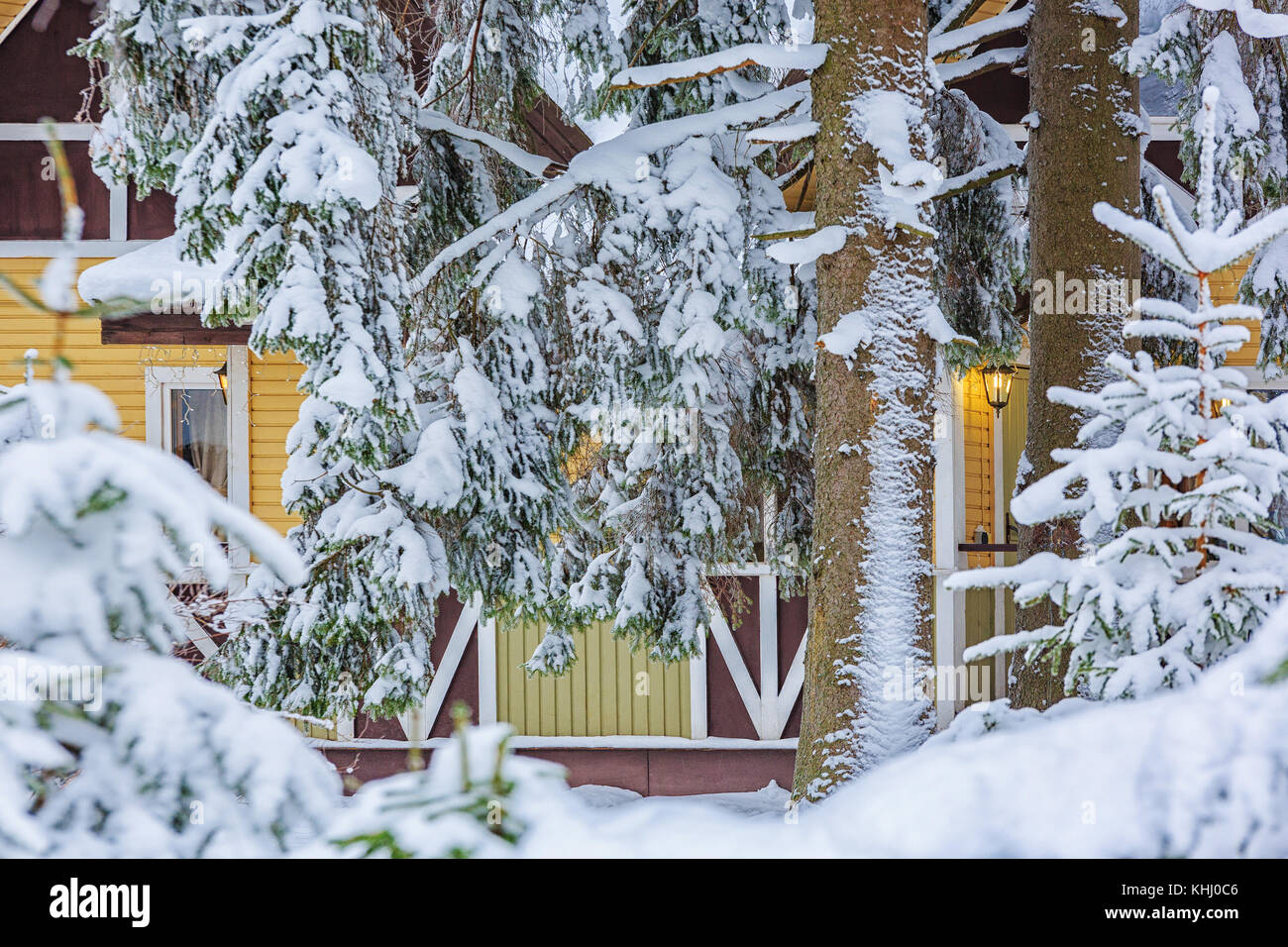 Une maison de repos dans une forêt couverte de neige d'hiver avec une lanterne et une guirlande. Banque D'Images