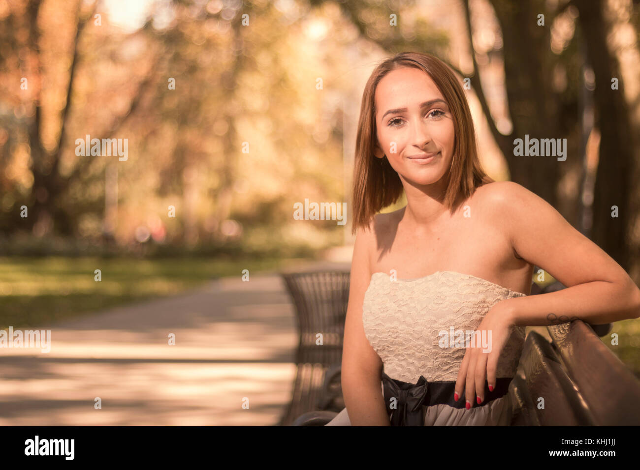 Une jeune femme, portrait en extérieur coloré automne nature park, à la recherche d'appareil photo, Banque D'Images
