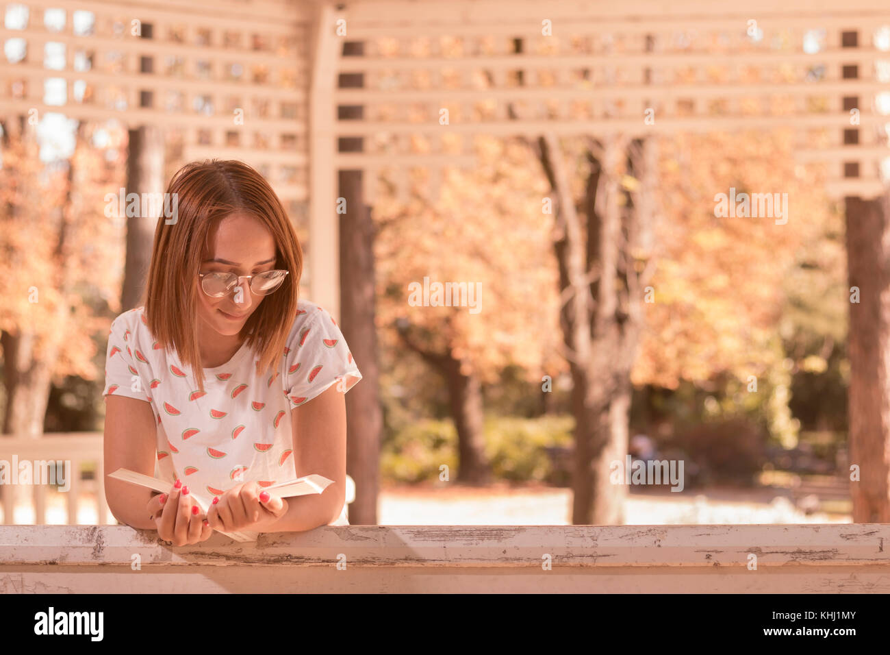 Une jeune femme lisant un livre à l'extérieur, portrait, journée ensoleillée, maison d'été Banque D'Images
