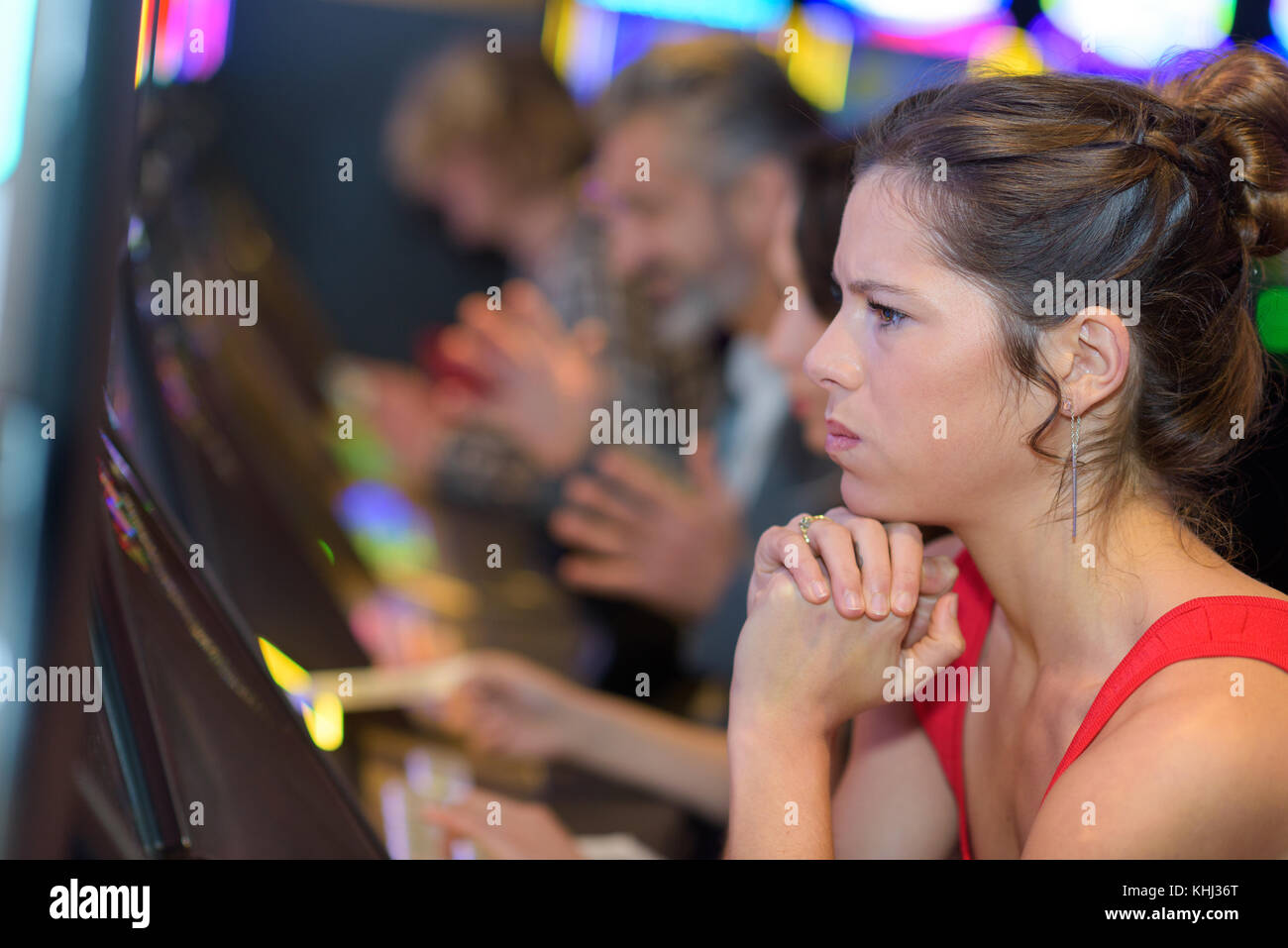 Belle femme en robe rouge jouer slot machine Banque D'Images