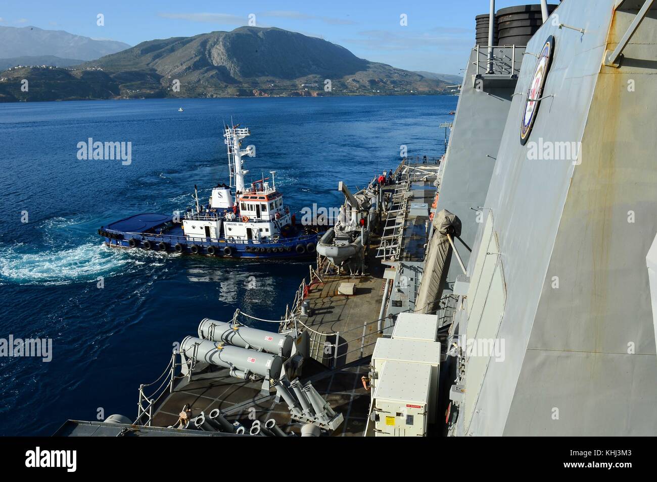 Un remorqueur aide la classe Arleigh Burke destroyer lance-missiles USS Po Banque D'Images