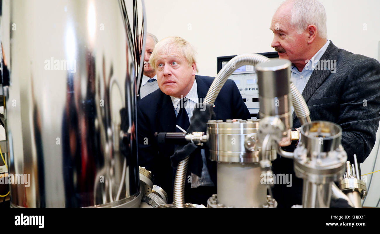 Boris Johnson, secrétaire aux Affaires étrangères, étudie un microscope à tunnel par balayage avec le professeur John Boland (à droite) au Trinity College de Dublin. Banque D'Images