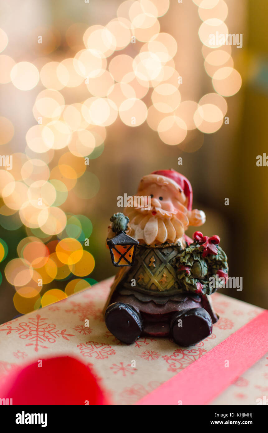 Décoration de Noël Le Père Noël en céramique boîte cadeau sur les lumières de Noël sur fond de flou artistique Banque D'Images