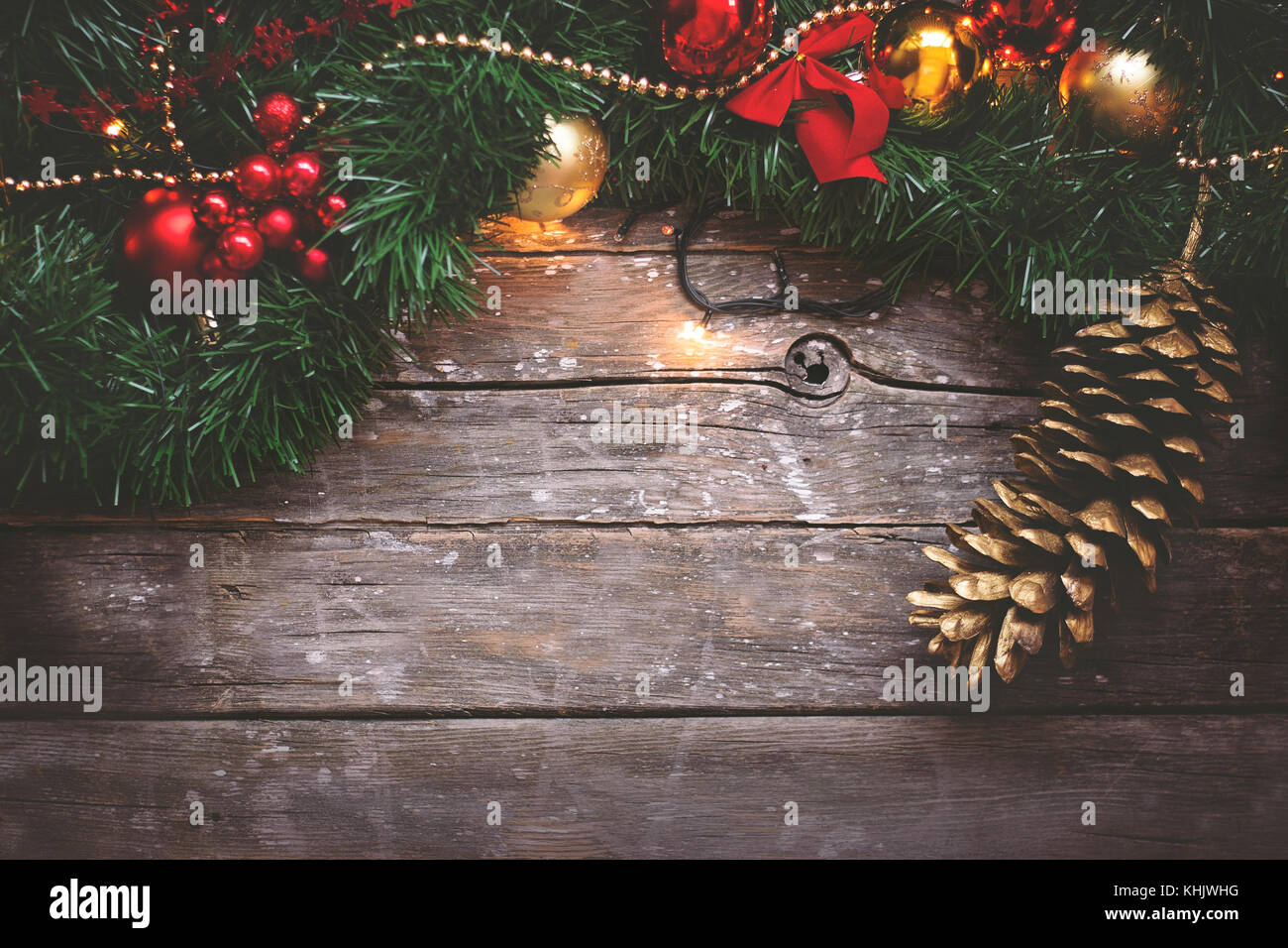 Noël arrière-plan - Garland, Golden et ornements rouge et de pin sur fond de bois foncé Banque D'Images