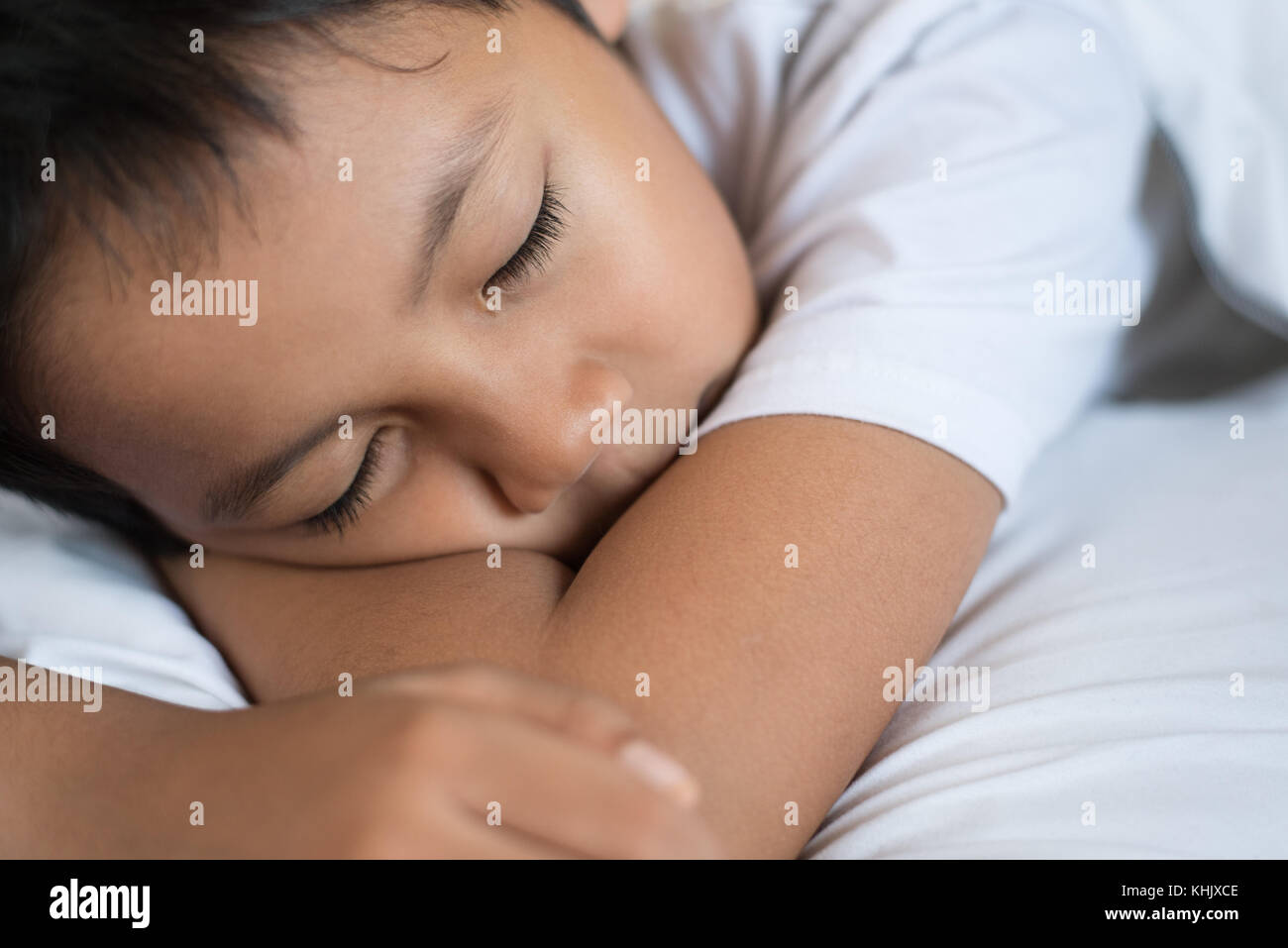 Le garçon endormi sur le lit avec drap blanc et l'oreiller.asian kid s'endormir rêver.sleep concept Banque D'Images