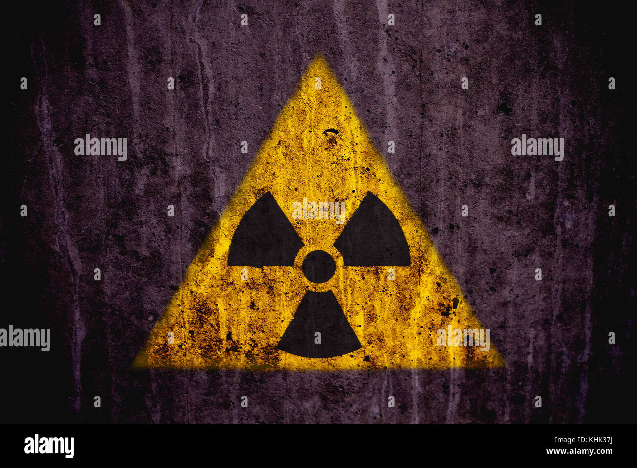 Radioactifs triangulaire jaune et noir (rayonnements ionisants) symbole de danger peint sur un mur en béton massif rustique foncé avec une texture grunge backgrou Banque D'Images