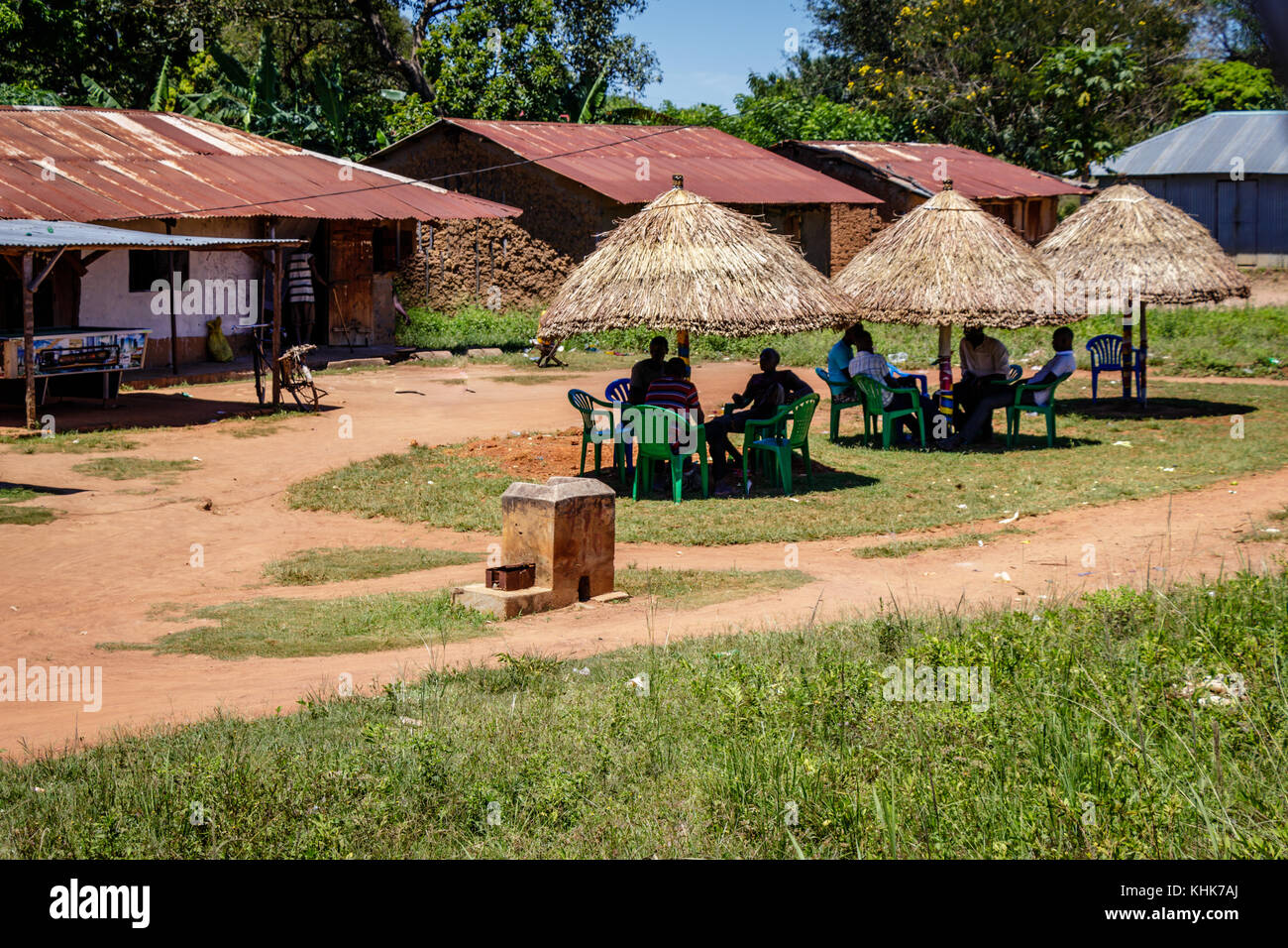 Un joli petit bar le long de la route de Mbale à Soroti en Ouganda. Les gens se détendent à l'ombre d'une cabane traditionnelle et boivent un coca. Banque D'Images