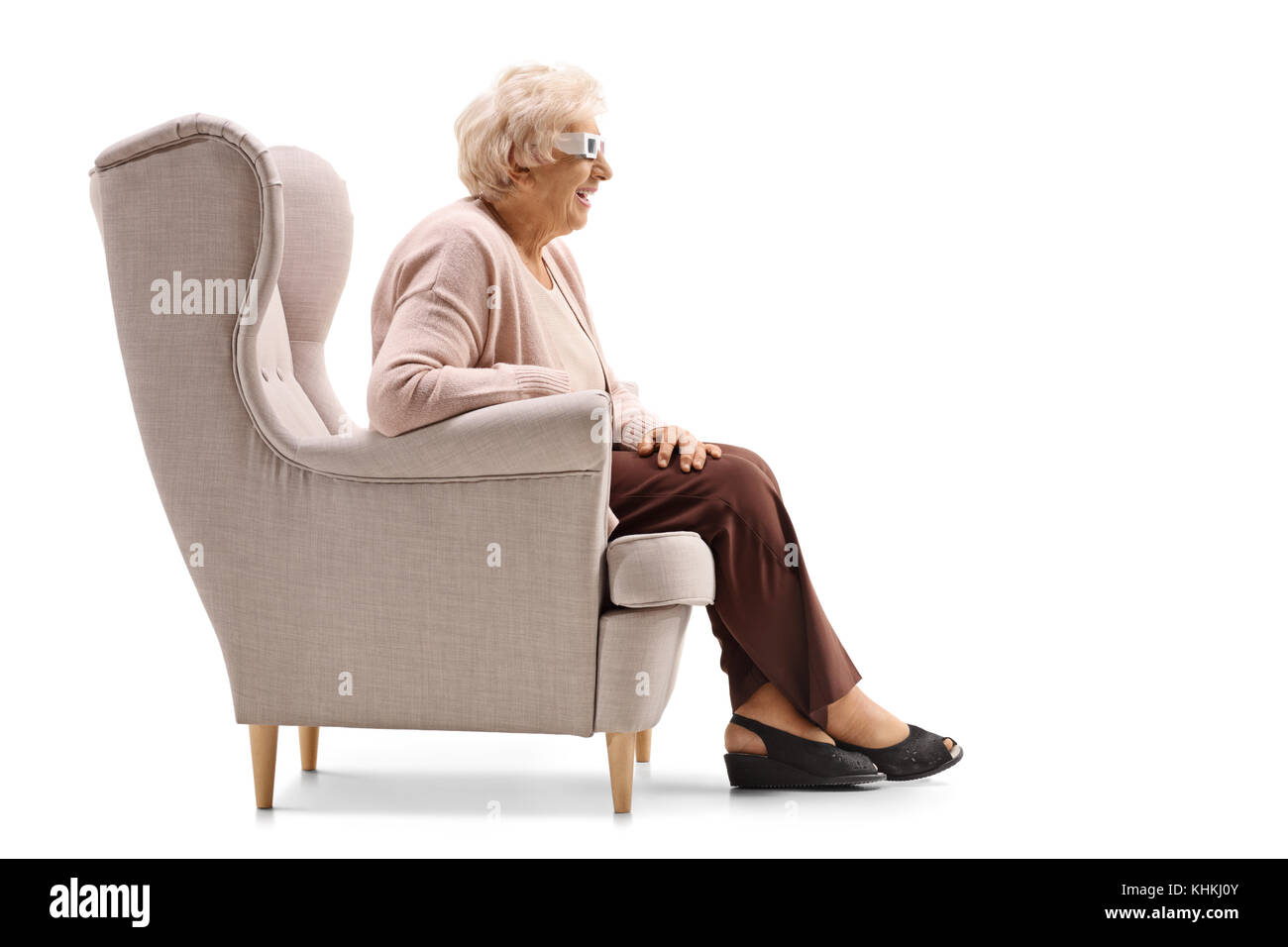 Senior lady avec une paire de lunettes 3d assise sur un fauteuil isolé sur fond blanc Banque D'Images