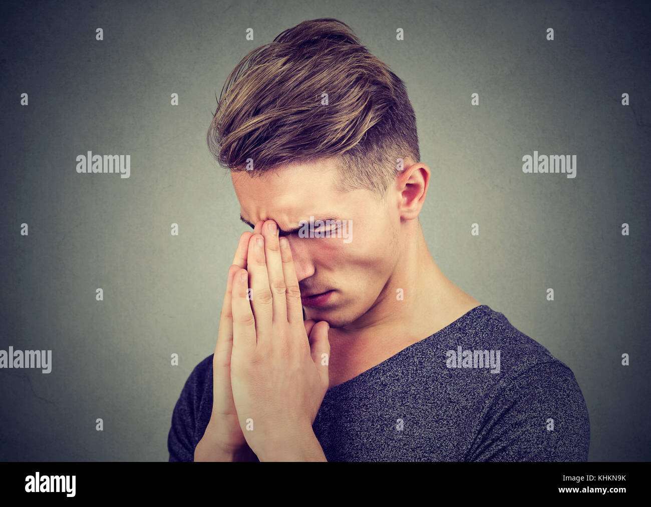 Homme triste avec expression visage tendus priant Banque D'Images