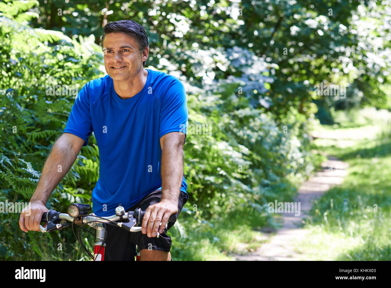 Vélo homme mûr le long du chemin dans la campagne Banque D'Images