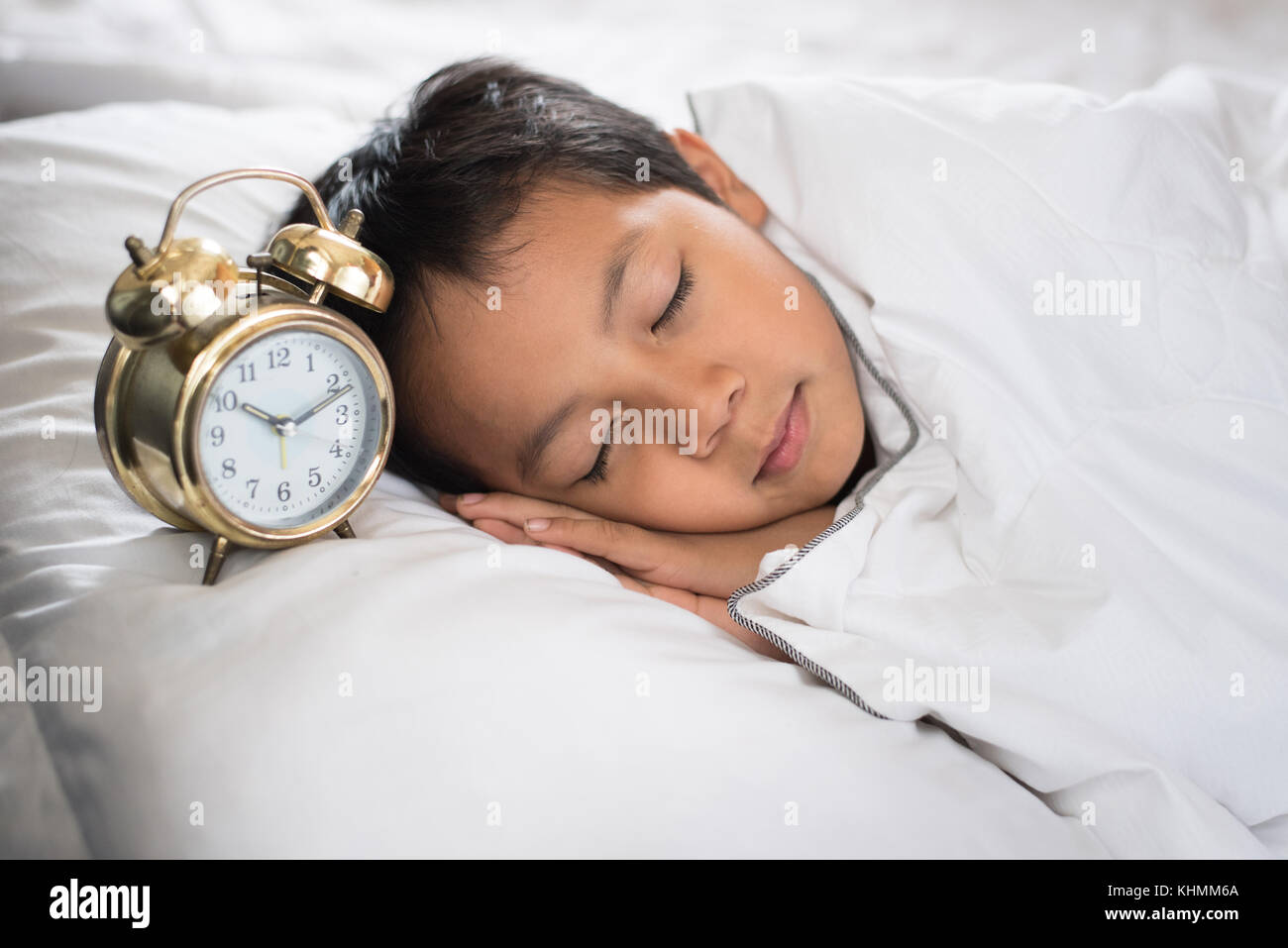 Jeune garçon endormi avec réveil sur le lit au matin.asian boy s'endormir.sleep concept Banque D'Images