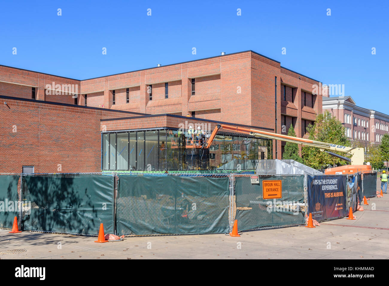 Deux hommes travailleurs de la construction sur un groupe mixte de travail de levage de la flèche télescopique sur un bâtiment de l'expansion à l'université auburn Auburn, Alabama, USA. Banque D'Images