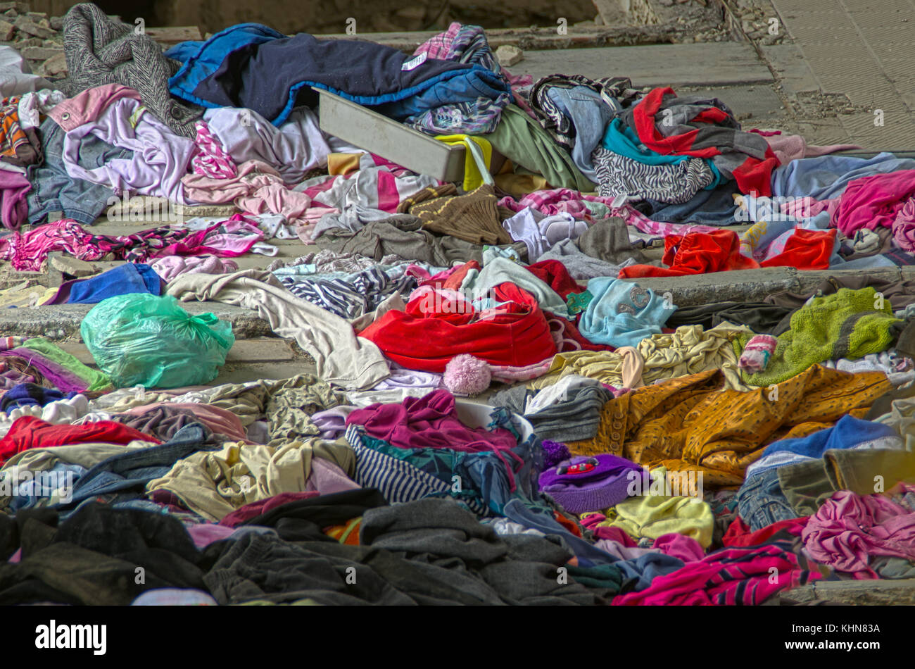 Abandonné de vieux tas de vêtements usés. Tissu coloré dispersés. Banque D'Images