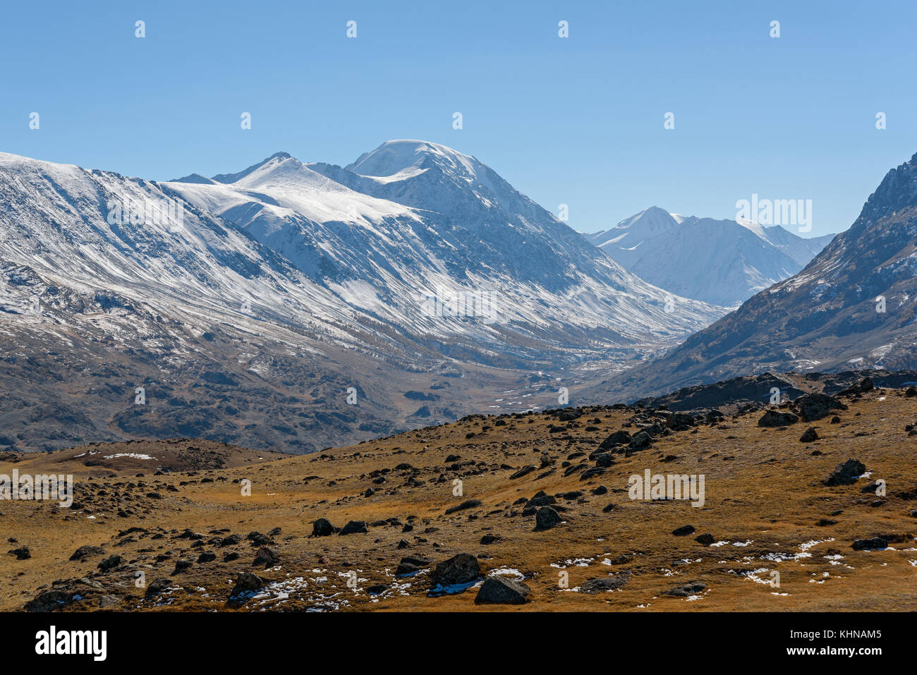 Automne pittoresque paysage de montagne avec des pierres et des montagnes couvertes de végétation éparse sur l'arrière-plan de montagnes de neige et ciel bleu Banque D'Images