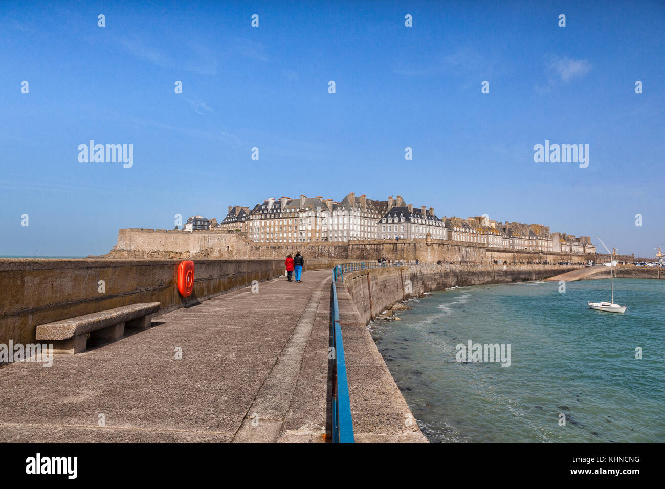 Saint malo sur un bel après-midi ensoleillé de printemps. une salle très habillé en train de marcher sur la jetée vers la vieille ville, qui a été reconstruit après avoir été... Banque D'Images