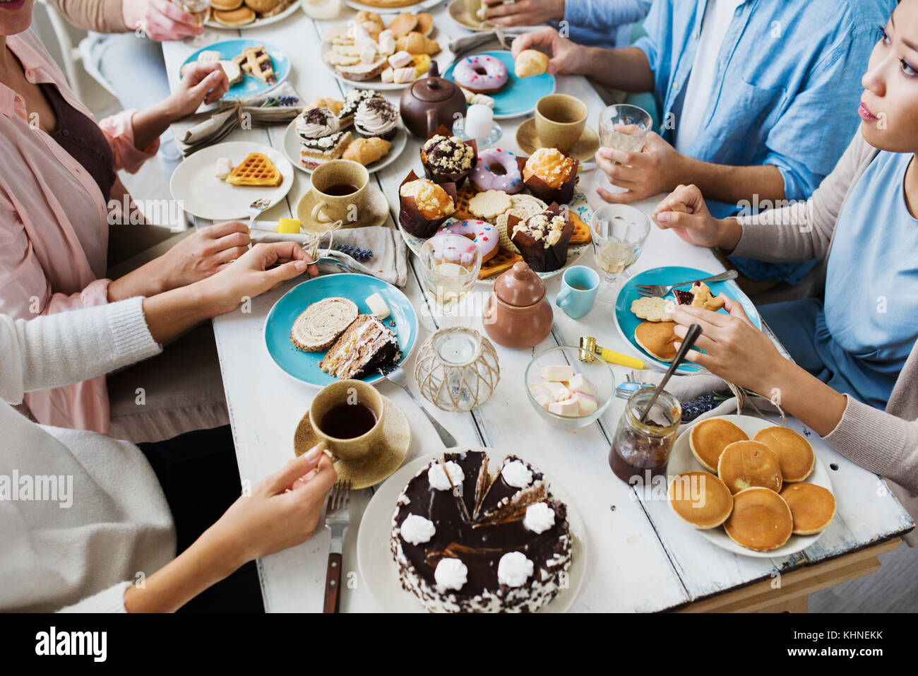 Groupe d'amis mangeant des desserts faits maison par table de fête Banque D'Images