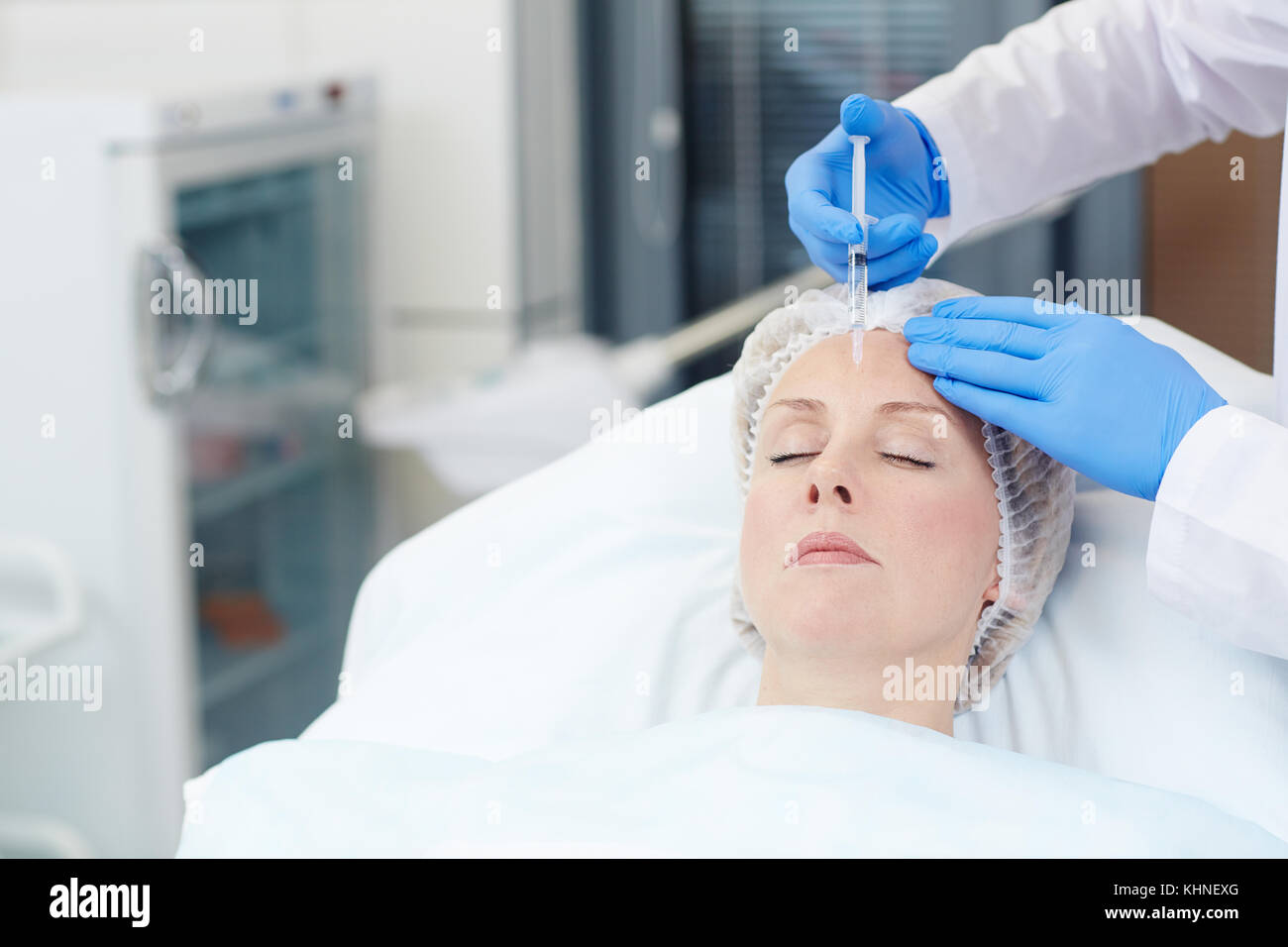 Vieillissement de la femme ayant l'injection anti-rides à son front Banque D'Images
