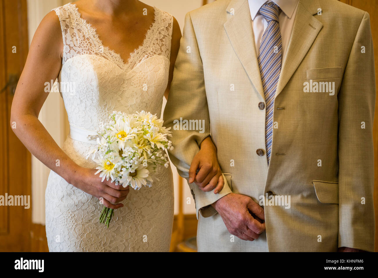 Mariée à être : une femme portant une robe de mariage, bras dessus bras  dessous avec son père, tenant un bouquet de fleurs blanches, marcher  jusqu'à la cérémonie de mariage, sur le
