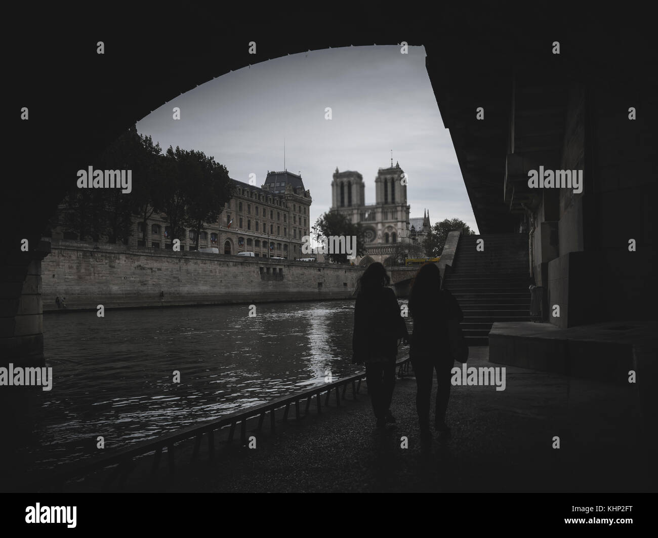 Deux femmes à pied sur le quai de la Seine à Paris, France avec vue sur la cathédrale Notre Dame Banque D'Images