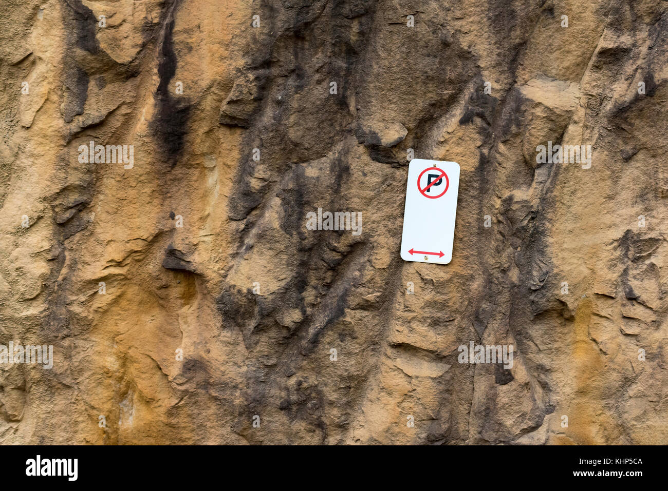Rouge et blanc no parking sign épinglé à un mur de grès à Sydney, Australie Banque D'Images