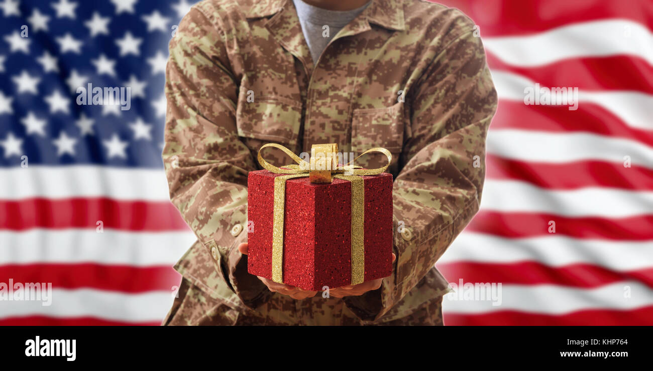 Noël dans le concept de l'armée. bal de Noël et boîte-cadeau sur un soldat américain en uniforme Banque D'Images