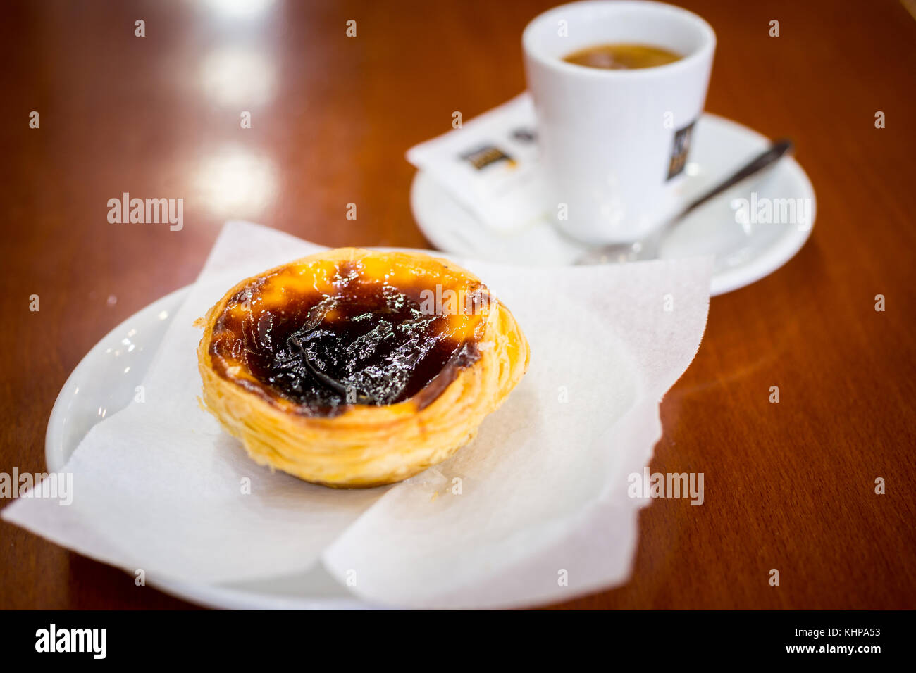 Tarte aux oeufs portugais et le café sur la table en bois brun dans une Pastelaria Banque D'Images