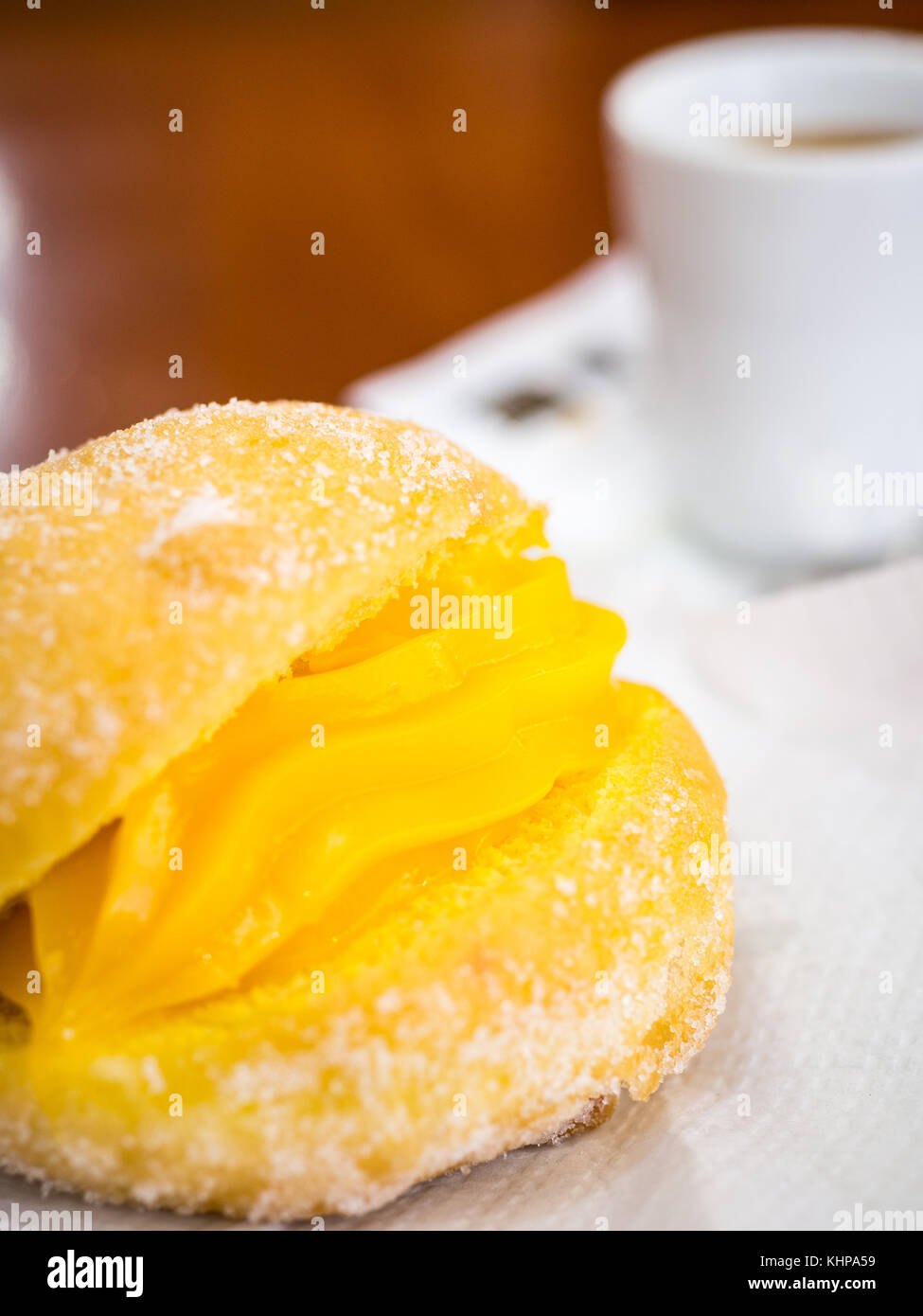 Donut portugais ou Berliner avec oeuf et crème de café sur la table en bois brun dans une Pastelaria Banque D'Images