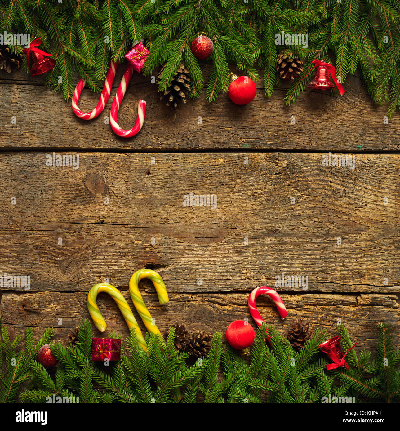 Sapin de noël avec des branches d'arbre, des cônes, des décorations de Noël et canne de Noël sur planches de bois rustique prêt pour votre conception Banque D'Images