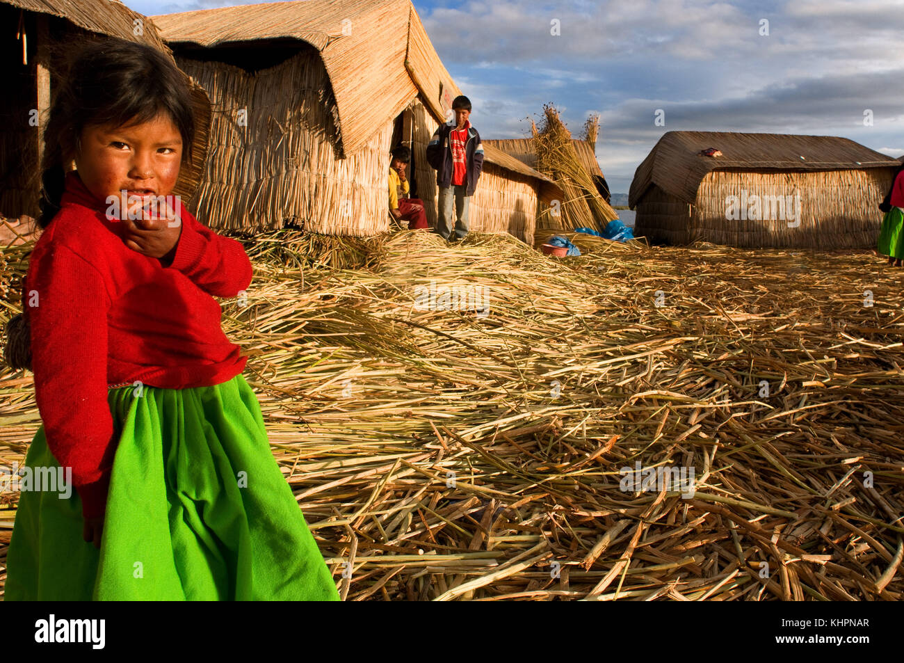 L'île uros, lac Titicaca, Pérou, Amérique du Sud. une fille aymara en costumes traditionnels de la région, composé d'une jupe verte intense et un col Banque D'Images