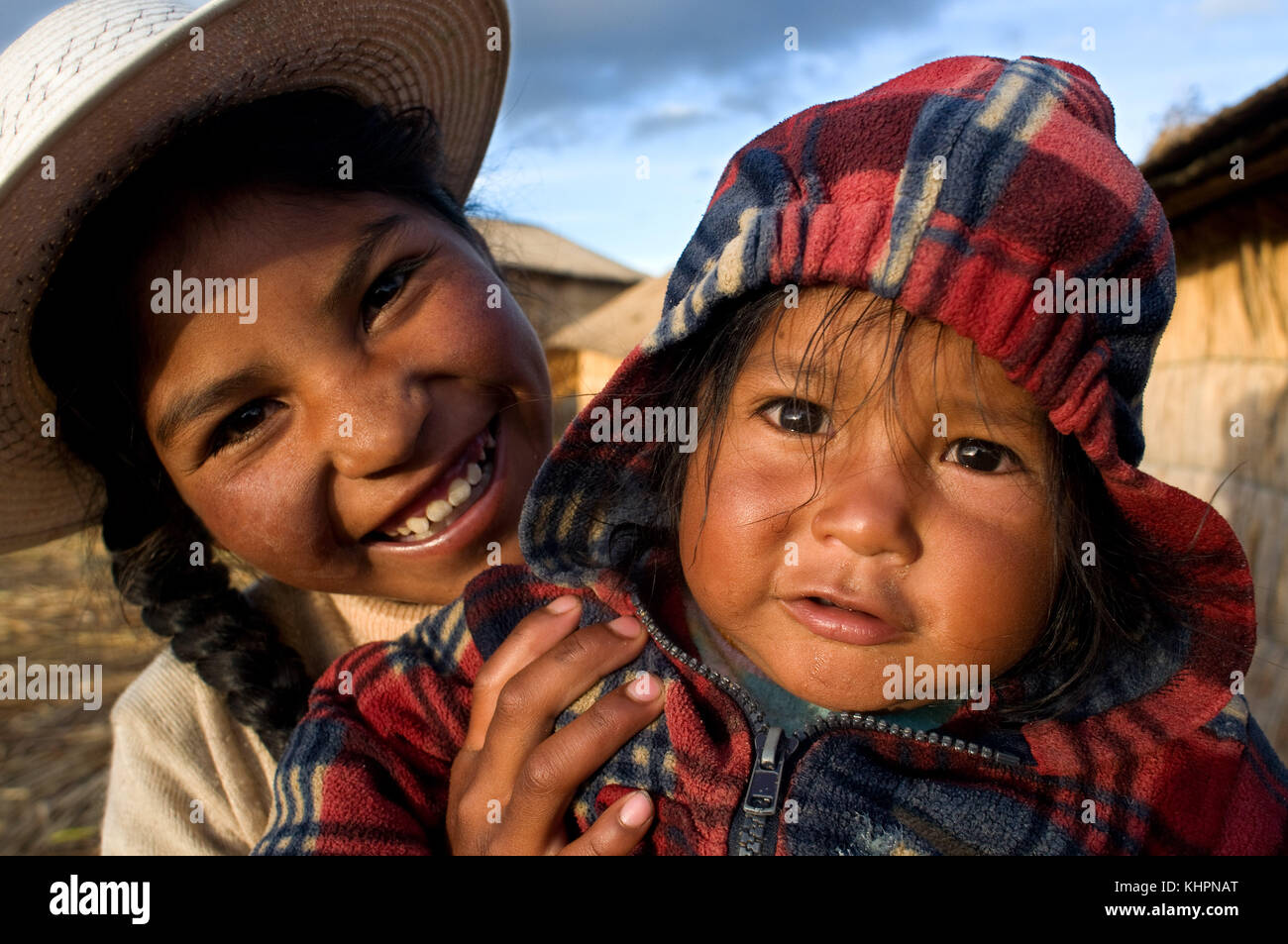 L'île uros, lac Titicaca, Pérou, Amérique du Sud. Certaines filles sur l'île de los Uros vêtues de leur costume régional typique au pied du lac de ti Banque D'Images