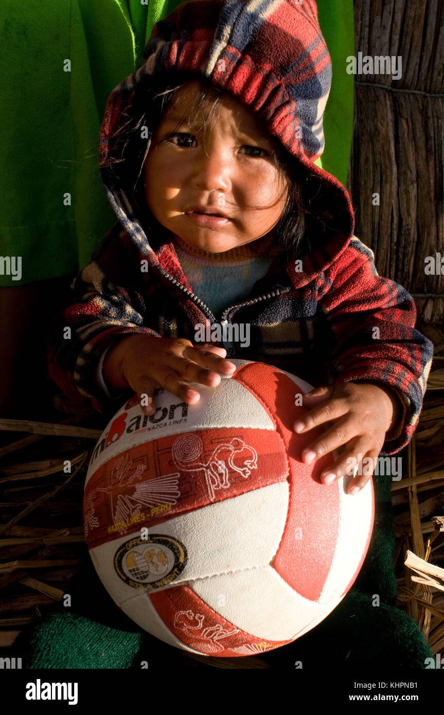 L'île uros, lac Titicaca, Pérou, Amérique du Sud. une fille sur l'île de los Uros lac Titicaca situé à l'intérieur de jouer avec un terrain de volley-ball. Banque D'Images