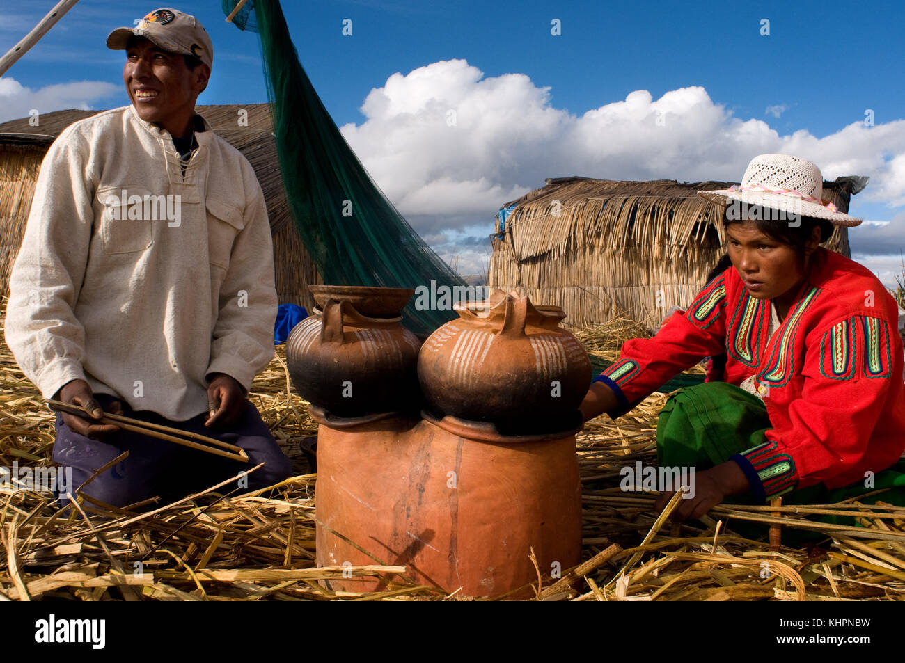 L'île uros, le lac Titicaca, au Pérou, en Amérique du Sud. une famille prépare le petit-déjeuner sur l'île de los Uros situé à l'intérieur du lac Titicaca. Banque D'Images