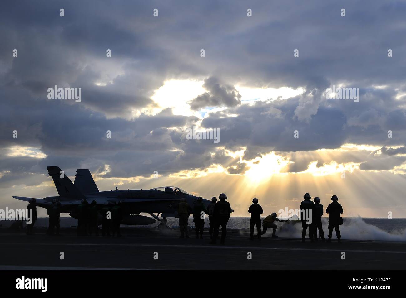 Un u.s. navy f/a-18c hornet jet fighter aircraft décolle de l'envol de la marine américaine de classe nimitz porte-avions USS Theodore Roosevelt au coucher du soleil le 11 novembre 2017 dans l'océan pacifique. (Photo par spencer roberts par planetpix) Banque D'Images